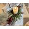 Unfinished logs are cut and ready to be made into a rustic Christmas decoration. Faux greenery and berries fill a vintage nail bucket. 